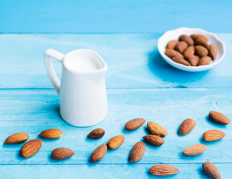 Almonds and milk arranged on table