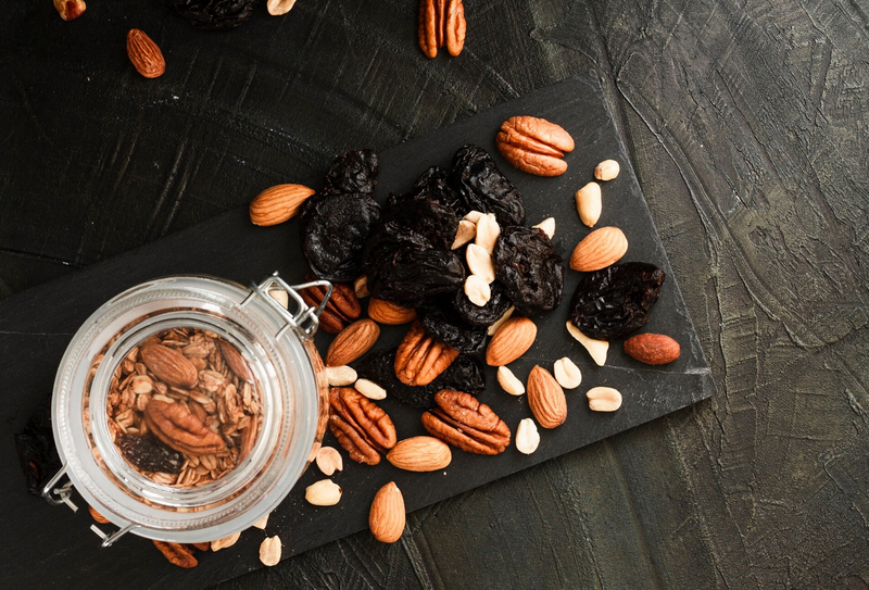 Nut mix in jar scattered on dark background