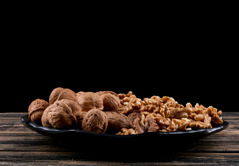 Whole and shelled walnuts in bowl