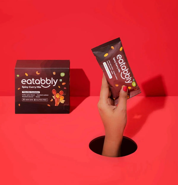 Hand holding a 'eatabbly' product against a red background